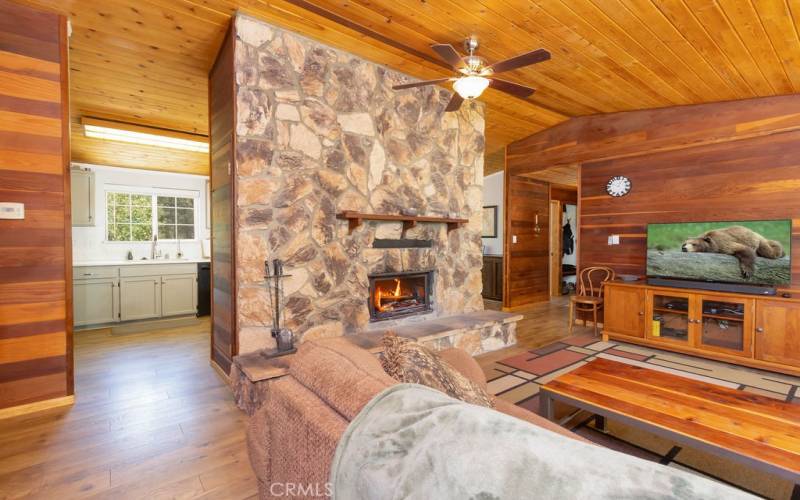 The fireplace provides a partial wall between the kitchen/dining room and the living area.