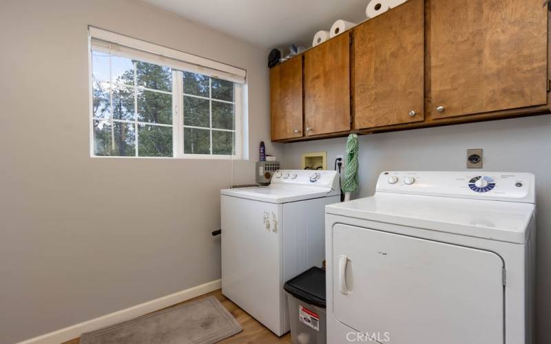 Near the entry is a laundry room with storage cabinets.