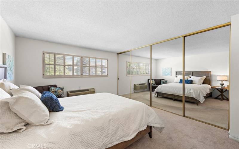 View of  the large Master bedroom w/wardrobe mirrors ,shutter window coverings.