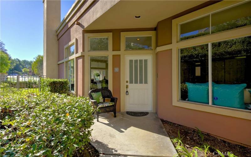 Well maintained landscape frames the the walk-way to the frosted-glass entry door.