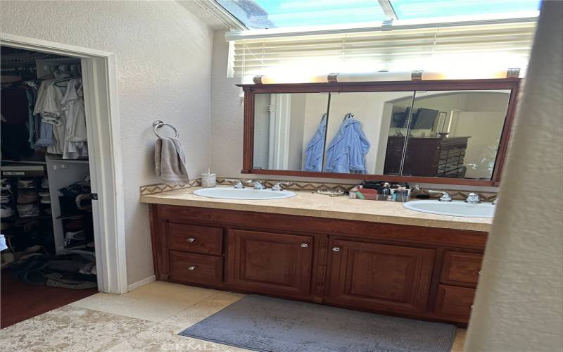 Primary bath with double sinks and walk-in closet