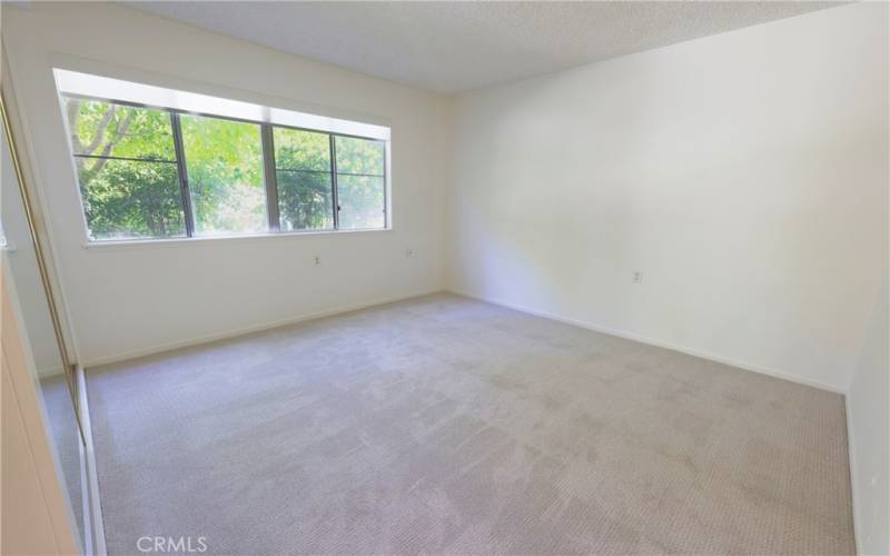 Very large bedroom with a window almost the length of th room