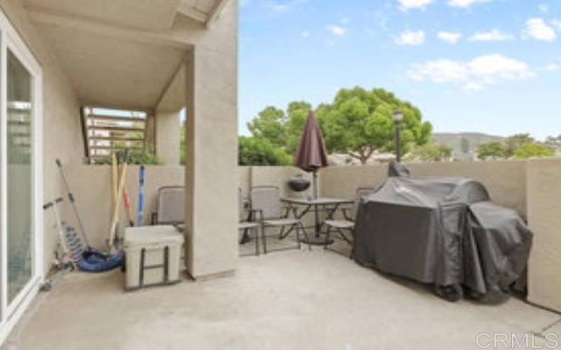 View from left side of patio area back toward the sliding doors and front door leading into the unit