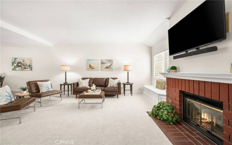 Spacious living room with Fireplace, window seat and new carpet area.