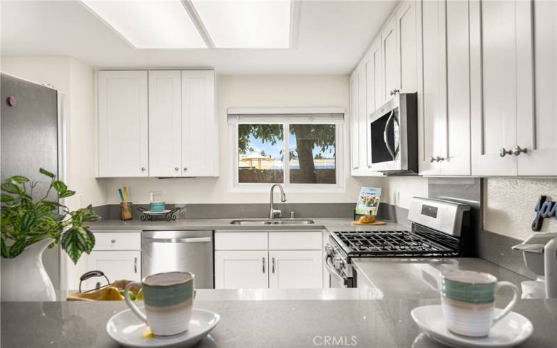 Remodeled kitchen with stainless steel appliances, double sink and quartz counters.
