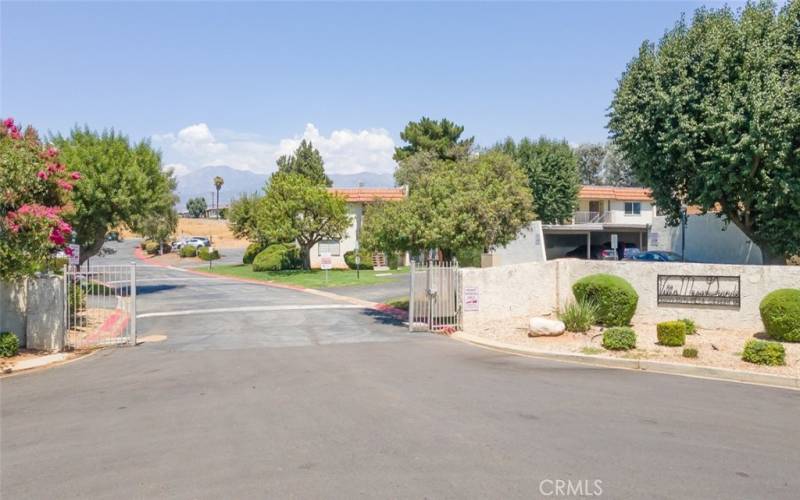 Welcoming gated community with lush landscaping, ample parking, and scenic mountain views.