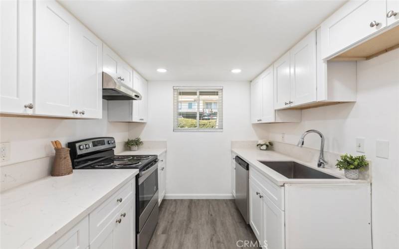 
Functional kitchen with sleek white cabinetry, modern appliances, and ample countertop space for meal preparation.