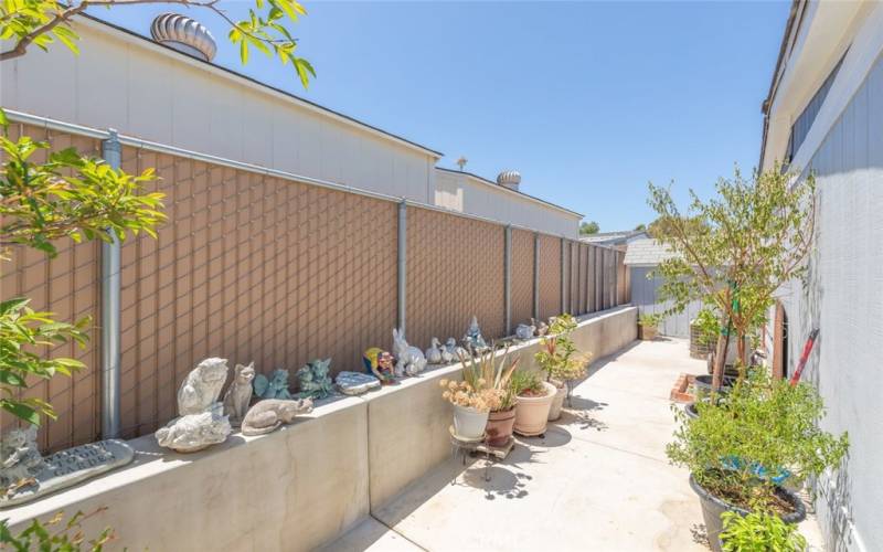 Spacious side yard with plenty of room to grow plants and showcase garden decorations.