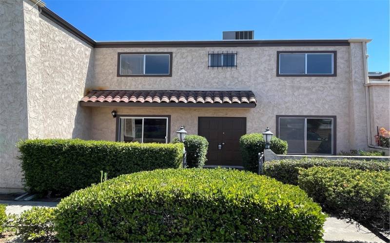 Front view of townhome with a gated courtyard entry with two patios. This north facing unit gets a ton of natural light through the windows.