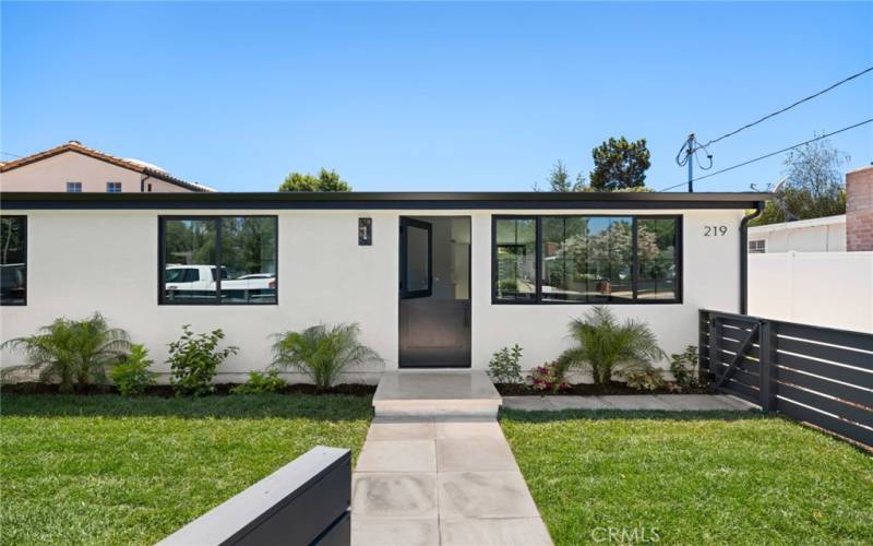 Front house fenced yard with gates off sidewalk and driveway