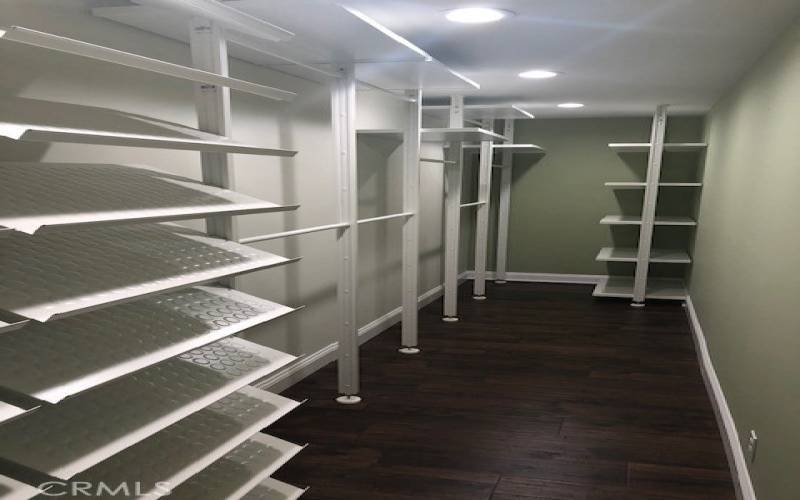 Large primary bedroom walk-in closet with shoe and sweater organizers