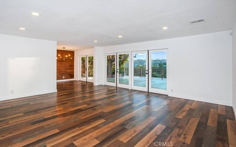 The expansive living room is drenched in natural light and is enhanced by recessed/dimmable LED lights, double French doors that highlight incredible sunsets as they descend behind El Scorpion Peak and rich wood laminate floors.