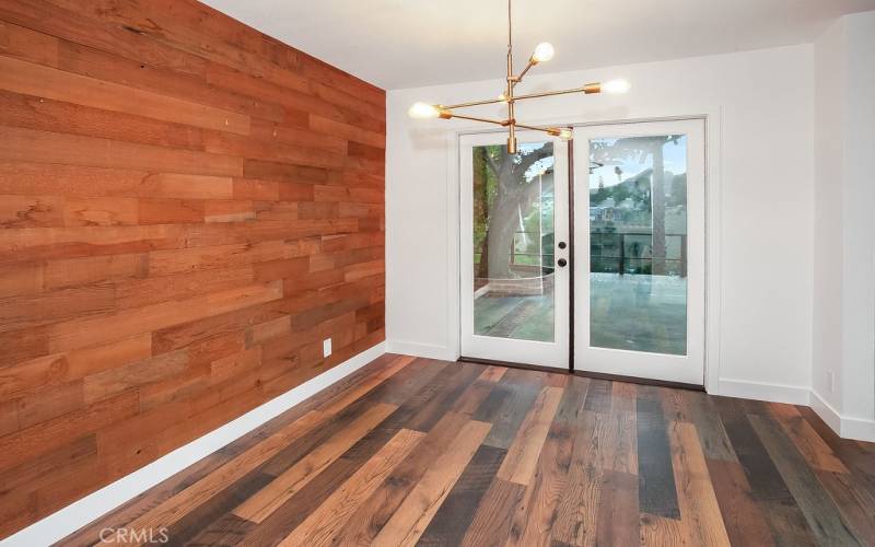 The formal dining room fittingly adjoins the kitchen and with its modern rough hewn wood accent wall, gold-toned chandelier with LED Edison bulbs, and French doors that frame incredible valley views, it is perfect for any occasion.