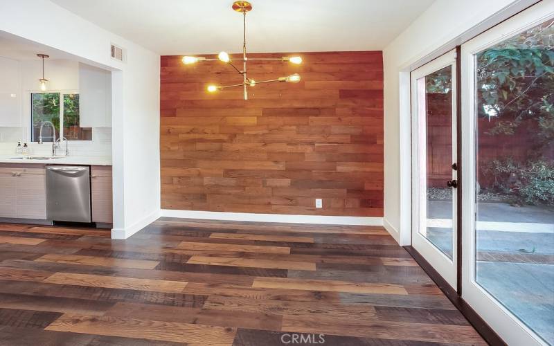 The formal dining room fittingly adjoins the kitchen and with its modern rough hewn wood accent wall, gold-toned chandelier with LED Edison bulbs, and French doors that frame incredible valley views, it is perfect for any occasion.