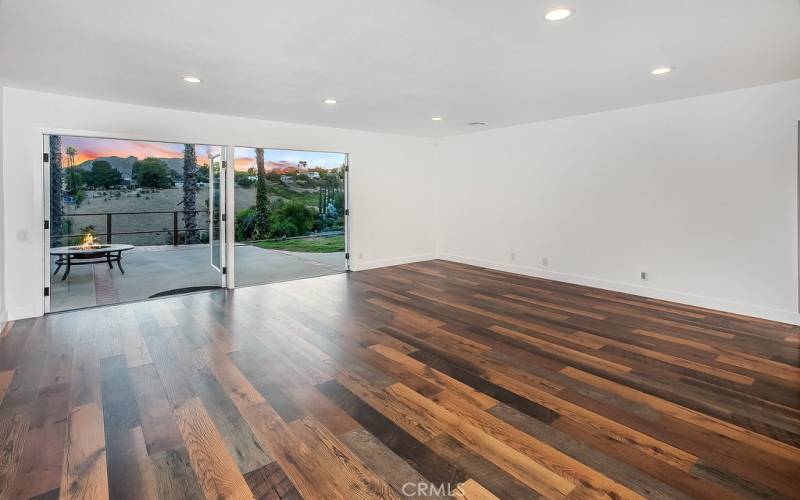 The expansive living room is drenched in natural light and is enhanced by recessed/dimmable LED lights, double French doors that highlight incredible sunsets as they descend behind El Scorpion Peak and rich wood laminate floors.