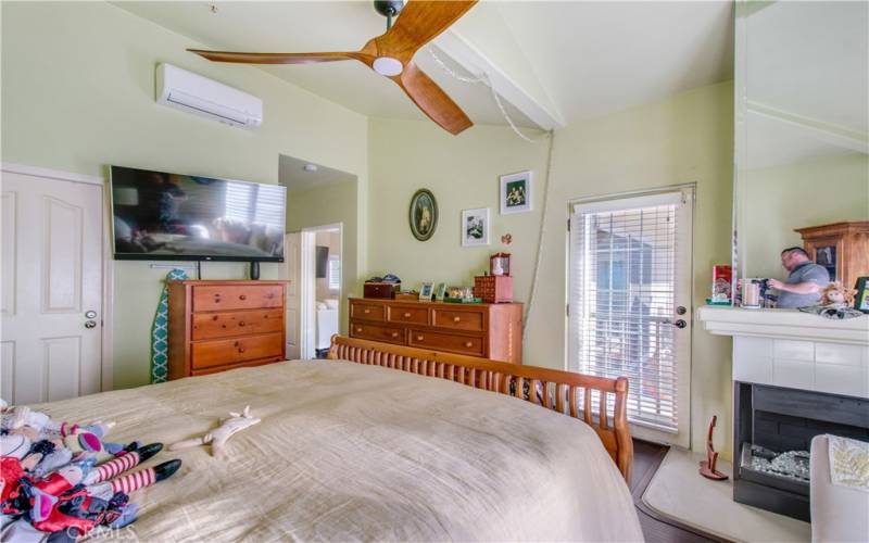 Primary bedroom, including second fireplace, private entry into large back patio and split AC unit to keep your bedroom cool during hot and humid summer months.