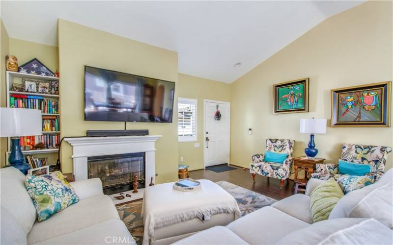 Living room, including vaulted ceiling, recessed lights, gas fireplace and mantle and padded laminate flooring.