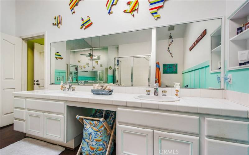 Huge primary bathroom including bright white counter tile, dual sinks, large mirrors and plenty of storage room.