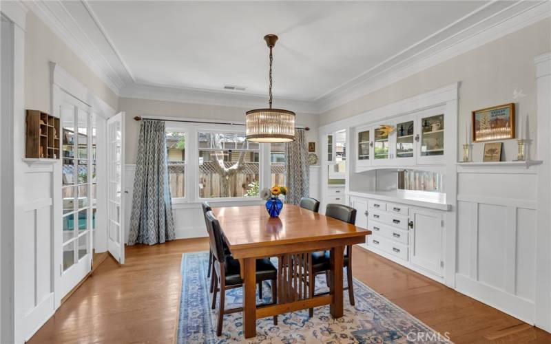 Formal dining room with original built-in buffet and French doors leading to the sunroom/office.