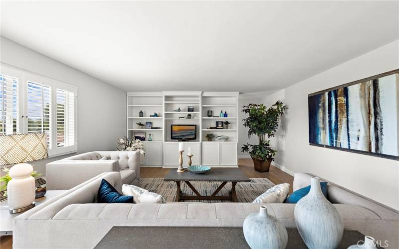 The living room with a built-in bookcase/entertainment center creates a storage alcove behind.