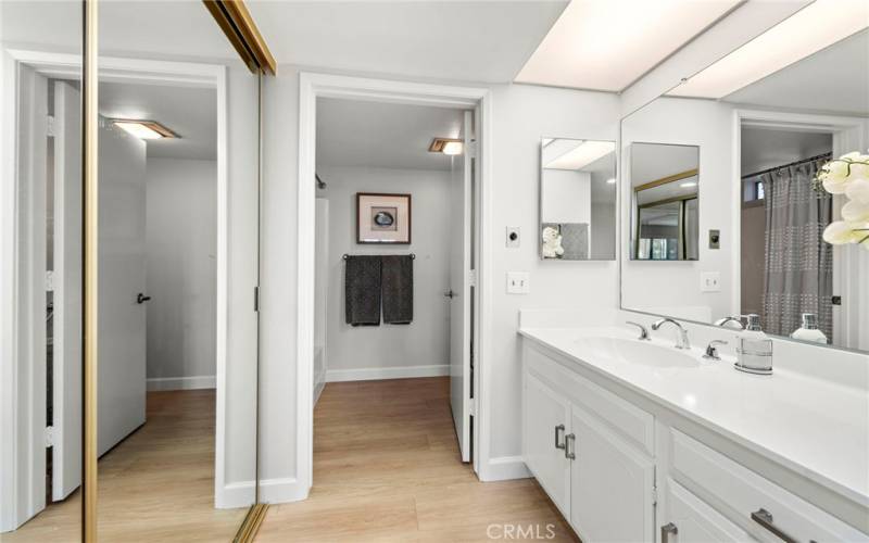 The primary bathroom features a tub with a shower above and a dressing area/vanity.