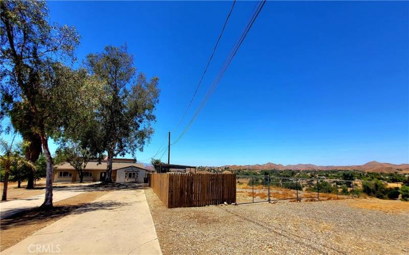 View of house and stable or gated parking yard.