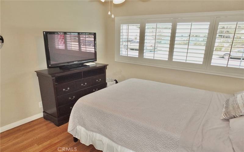 Gorgeous white shutters add to the elegance of this front bedroom