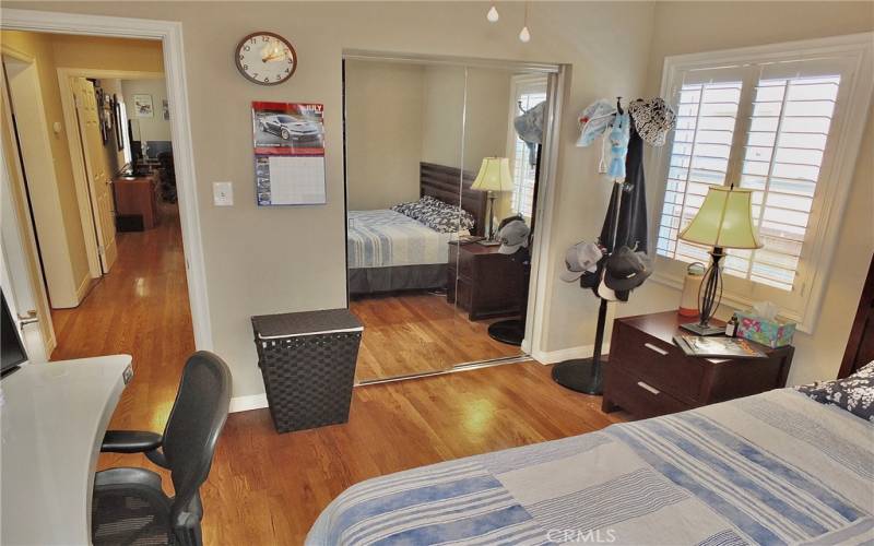 View of mirrored wardrobe closet and gorgeous wood flooring.