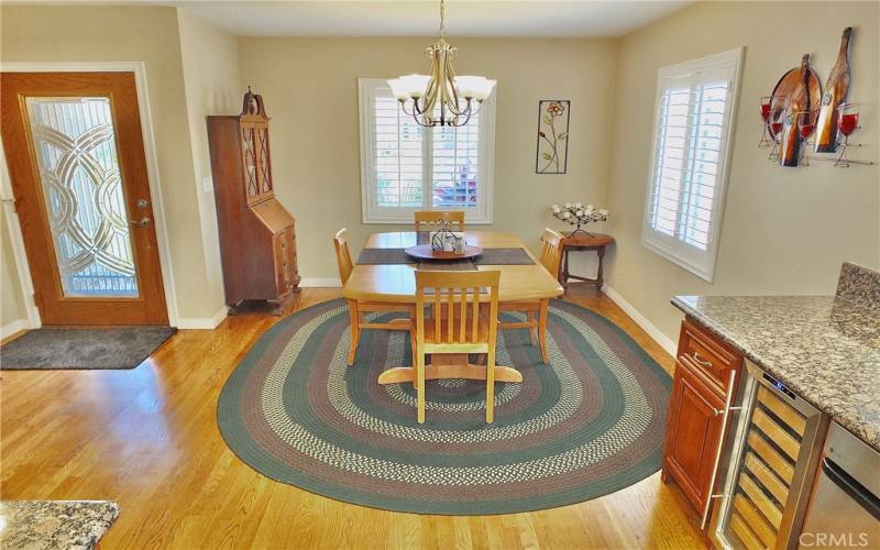 Step into this inviting dining room, where natural light streams through beautiful shutters, casting a warm glow across the space. The elegant chandelier overhead adds a touch of sophistication, creating the perfect ambiance for memorable meals with family and friends.