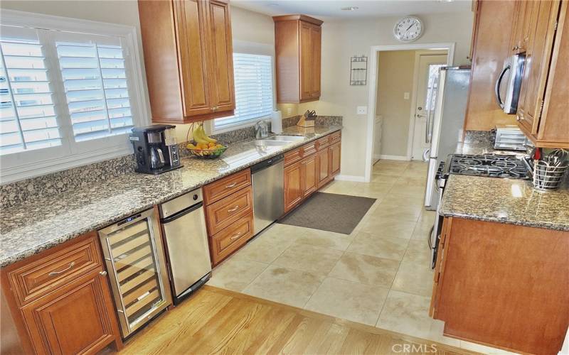 View of the wine refrigerator underneath long granite countertop