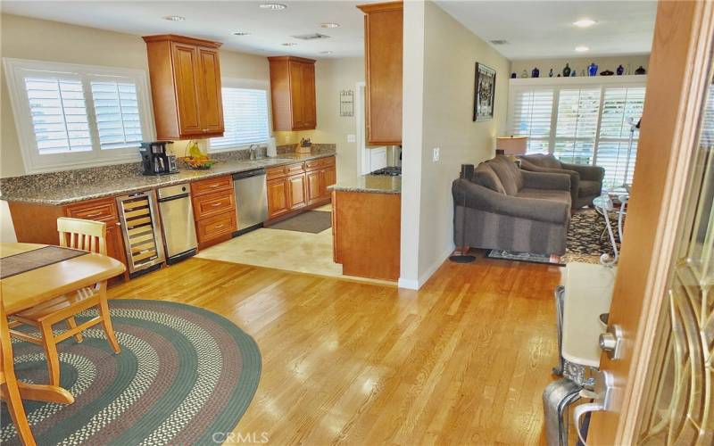 Gorgeous wood flooring flows seamlessly into the dining room, kitchen, and living room.