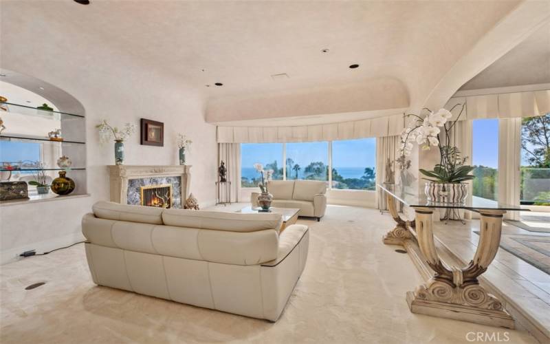 Ocean view Living room open to dining room with patio doors to outdoors.