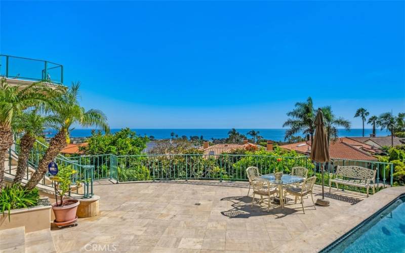 Pool, patio area and view of ocean.