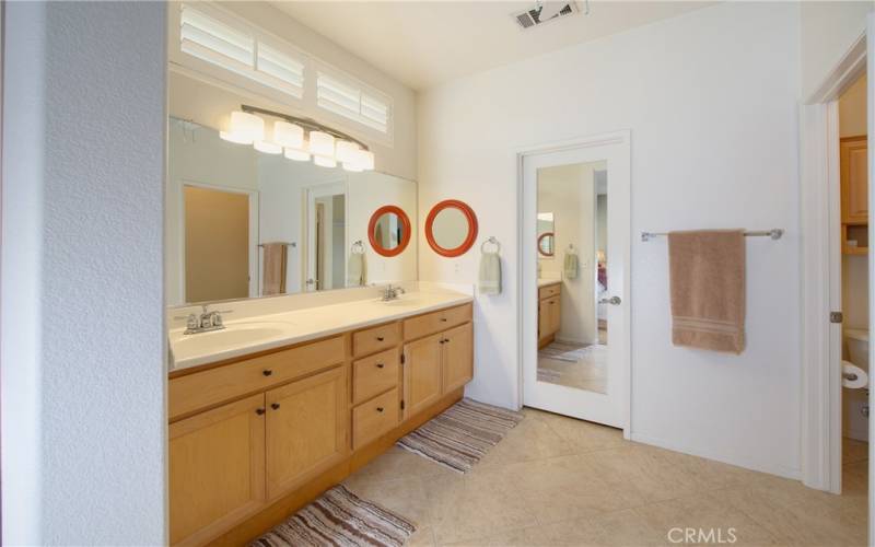 The master bath has a dual sink vanity, tile floor, shower, privacy door commode and walk-in closet with mirrored door.