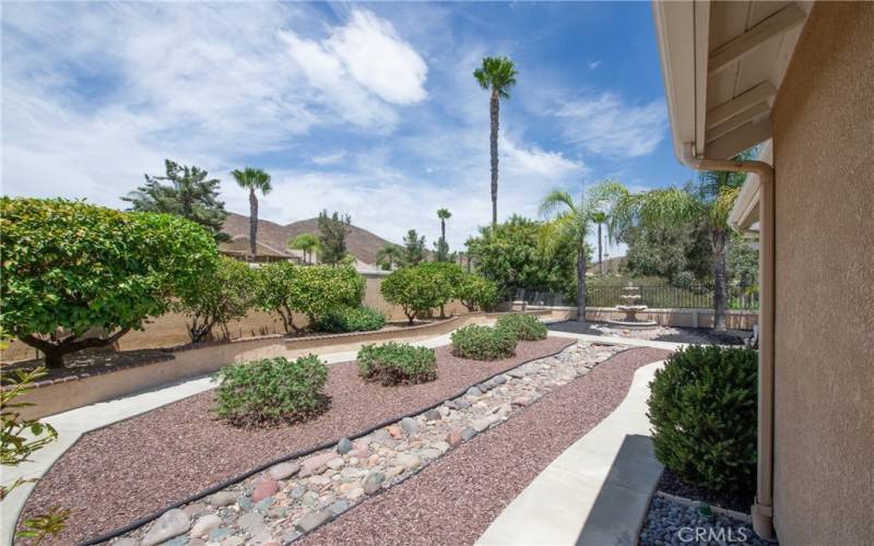 Side yard with beautiful gardens, fruit trees, mountain and golf course views.