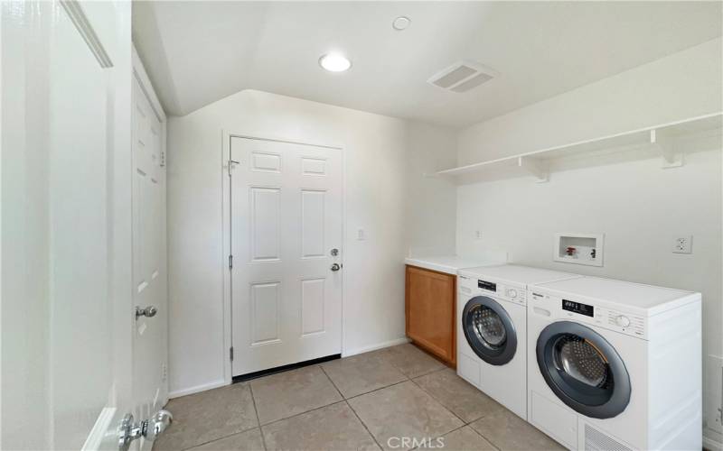 Laundry area that is connected to the under  the stairs storage and also leads to 2 car attached garage  w/ tankless water heater. virtually staged