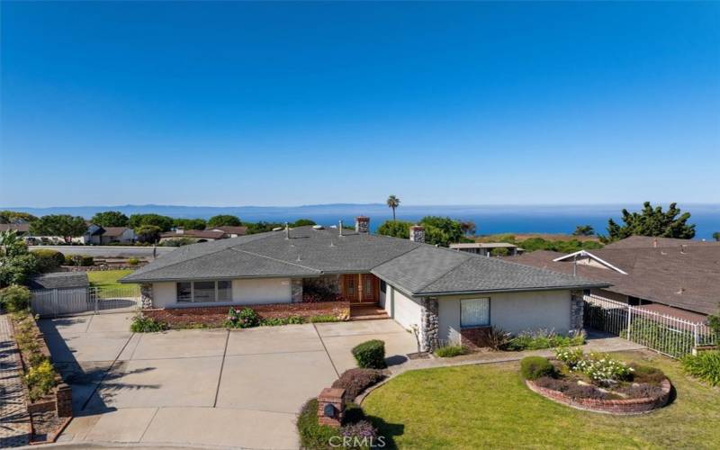 Front of house - drone shot, with ocean and Catalina views in the background.