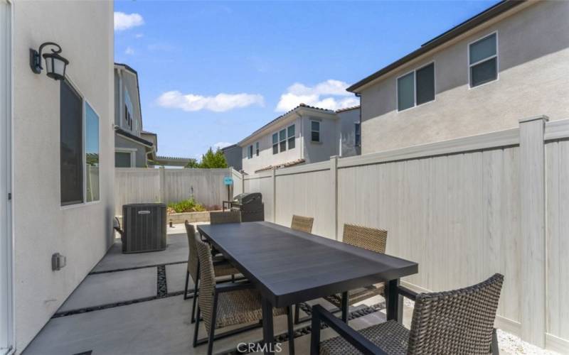 UPGRADED BACKYARD PATIO CONCRETE TRAVEL PATH. FULL LANDSCAPING INCLUDES IRRIGATED FLOWER BED WITH RETAINING WALL AND PATTERNED GROUND DESIGN WITH IN-GROUND GUTTER DRAINAGE