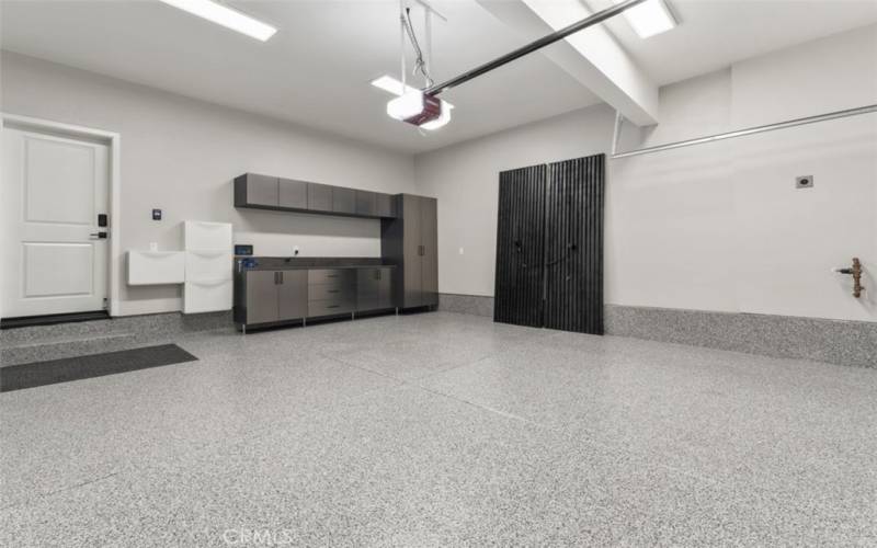 UPGRADED GARAGE EPOXY FLOORING COATING SYSTEM. WITH  TWO 240-V EV CHARGING OUTLET AND WALL MOUNTED VACUUM WITH EXTENDED HOSE. ALSO FEATURES DESIGNER STORAGE CABINETS AND WORK BENCH. FEATURES A WIRELESS GARAGE DOOR OPENER KEY PAD.