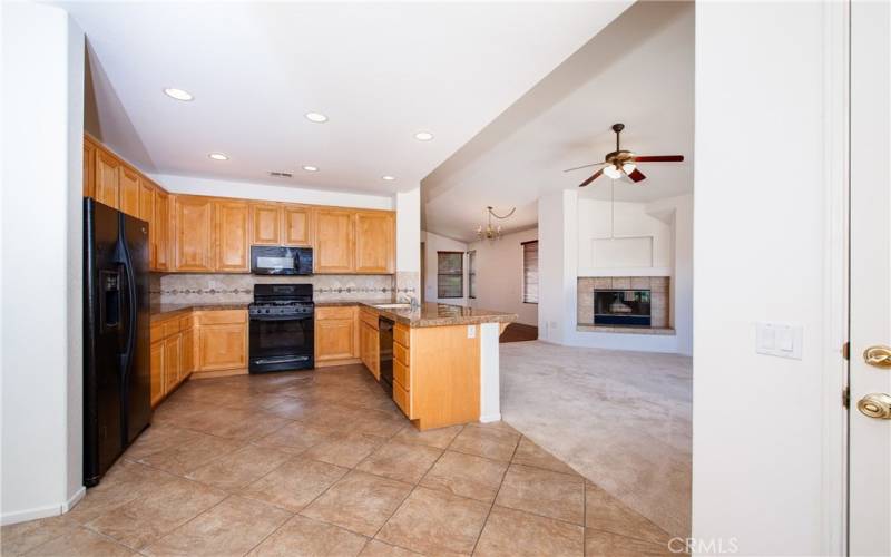 Beautiful kitchen with tile floors, granite counters, custom tiled backsplashes opening to the family room.