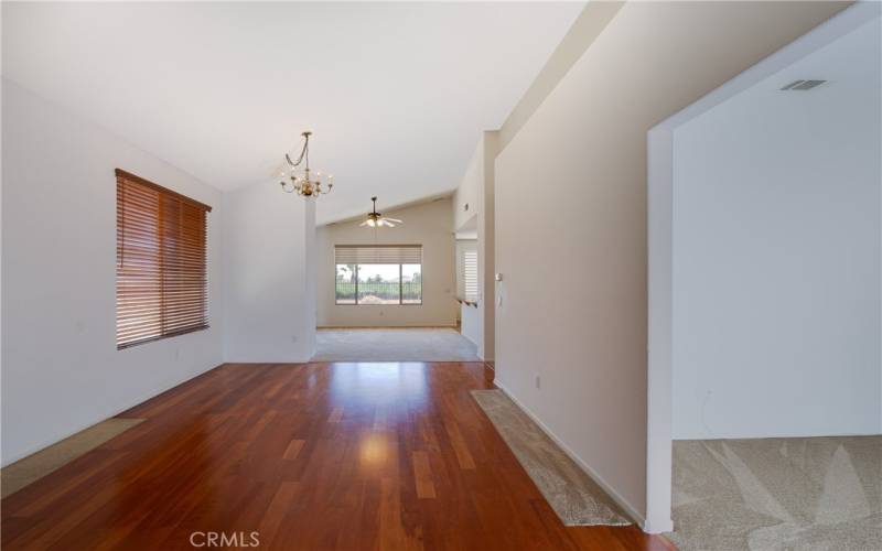 The living/dining room features wood type laminate floors, soaring ceiling and ceiling fan. Flex room to the right usable as a den, office, music room or convert to a 3rd bedroom.