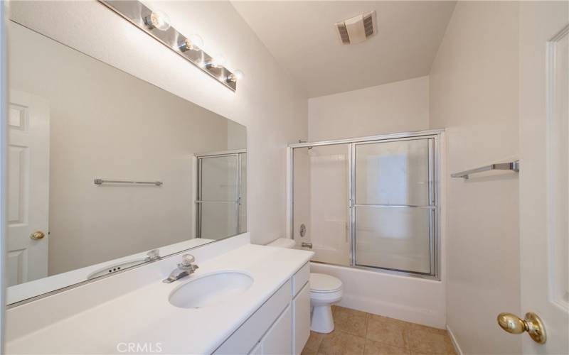 Guest bedroom with enclosed tub and shower.