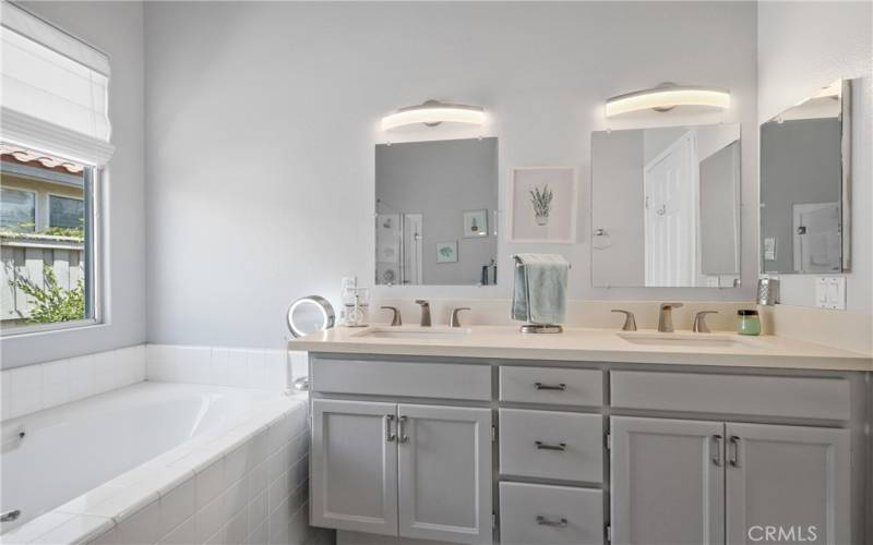 Primary bath has quartz countertops, designer lighting and updated fixtures