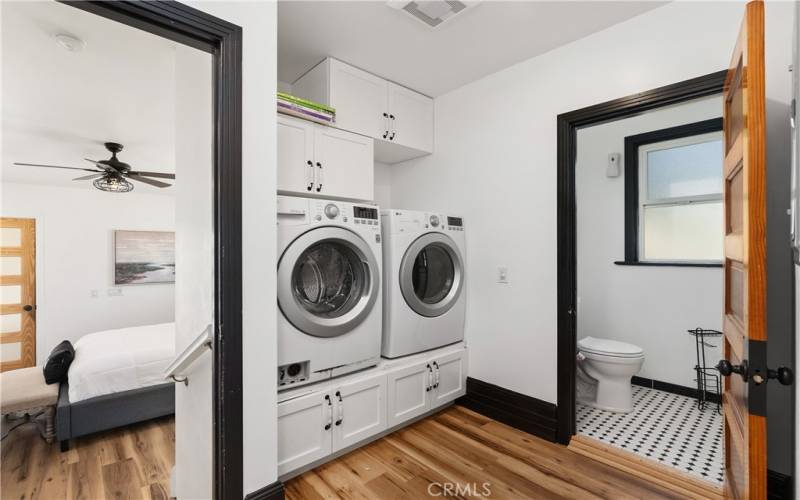 The laundry area has a 1/2 bath. Very convenient for guests. To the left is the entry to the downstairs primary bedroom.