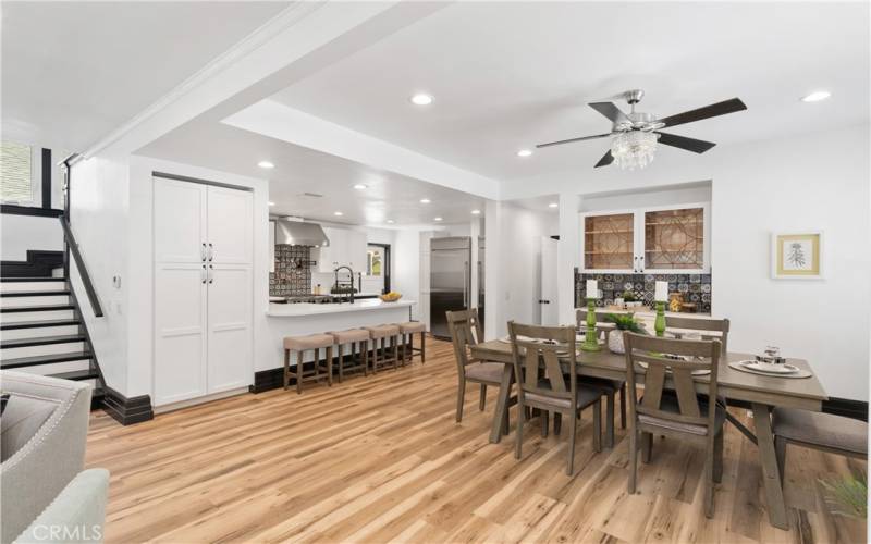 This view shows off the stairs and the kitchen and how the recessed lighting creates a bright space for everyone. Let's head upstairs.