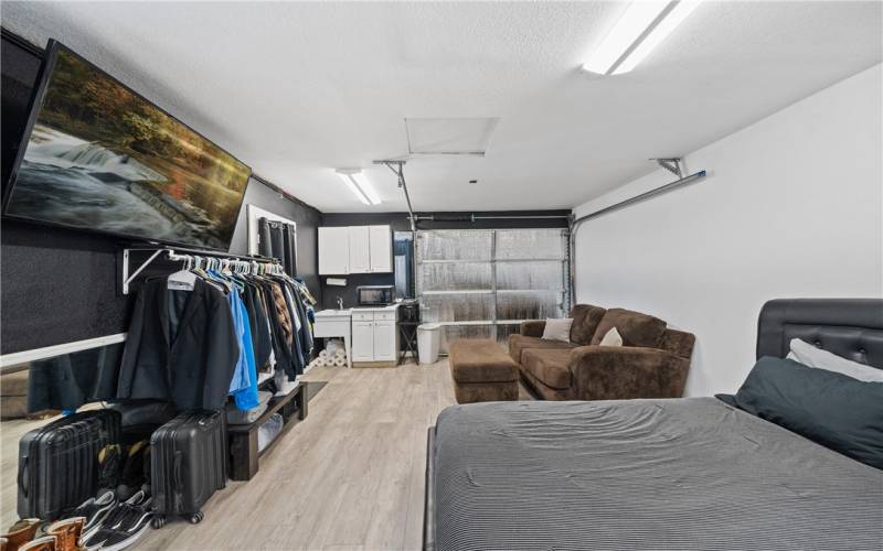 Detached single car garage used as living space features plumbing, a toilet, sink, and shower