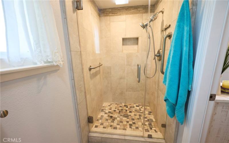 Beautiful walk-in shower with seamless glass door and showerhead with water filter