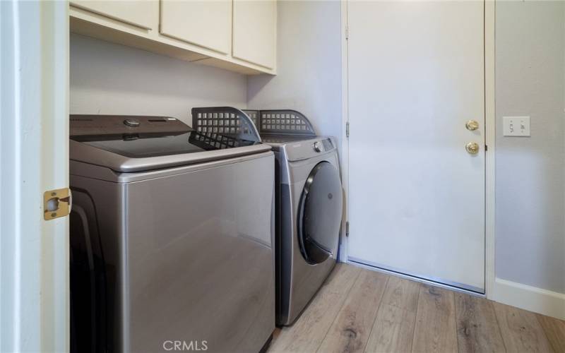 Inside laundry room leads to double car garage with epoxy flooring and extra storage