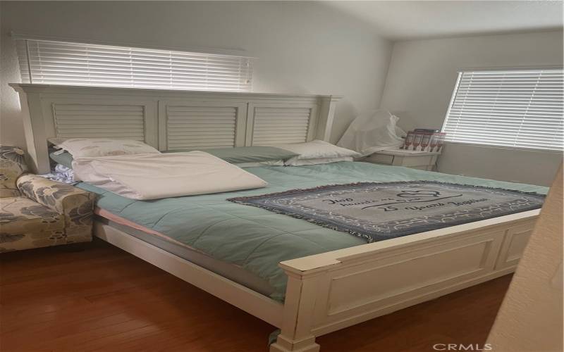 Primary bedroom with wood flooring