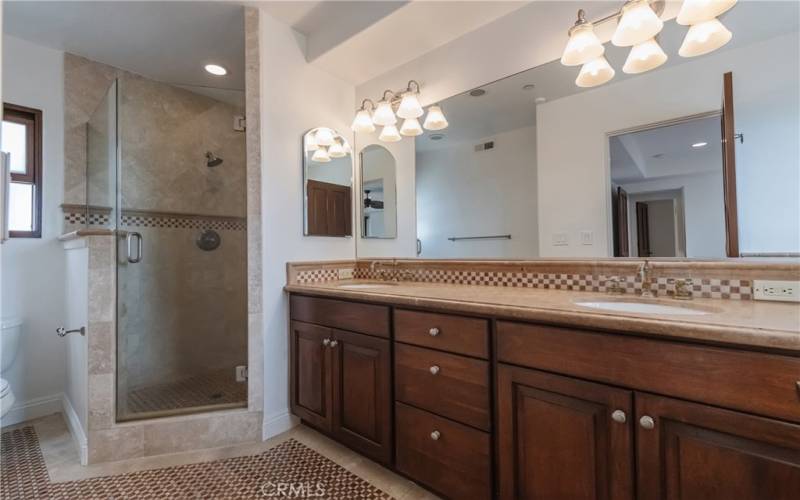 Primary suite's bathroom with separate shower, huge vanity with double sinks, and tub